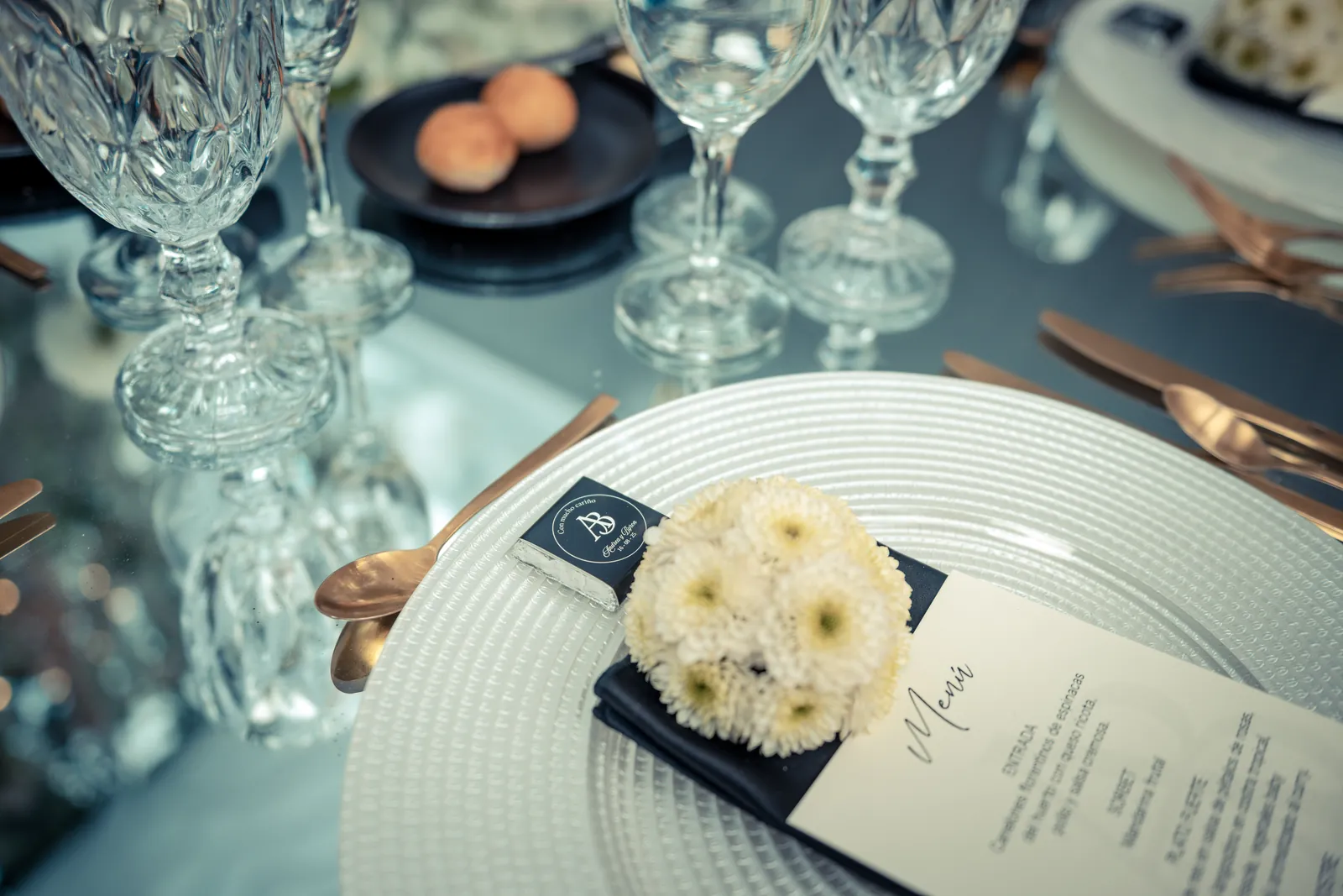 Detalle de puesto de mesa con menú y monograma A&B en la boda de Andre y Byron