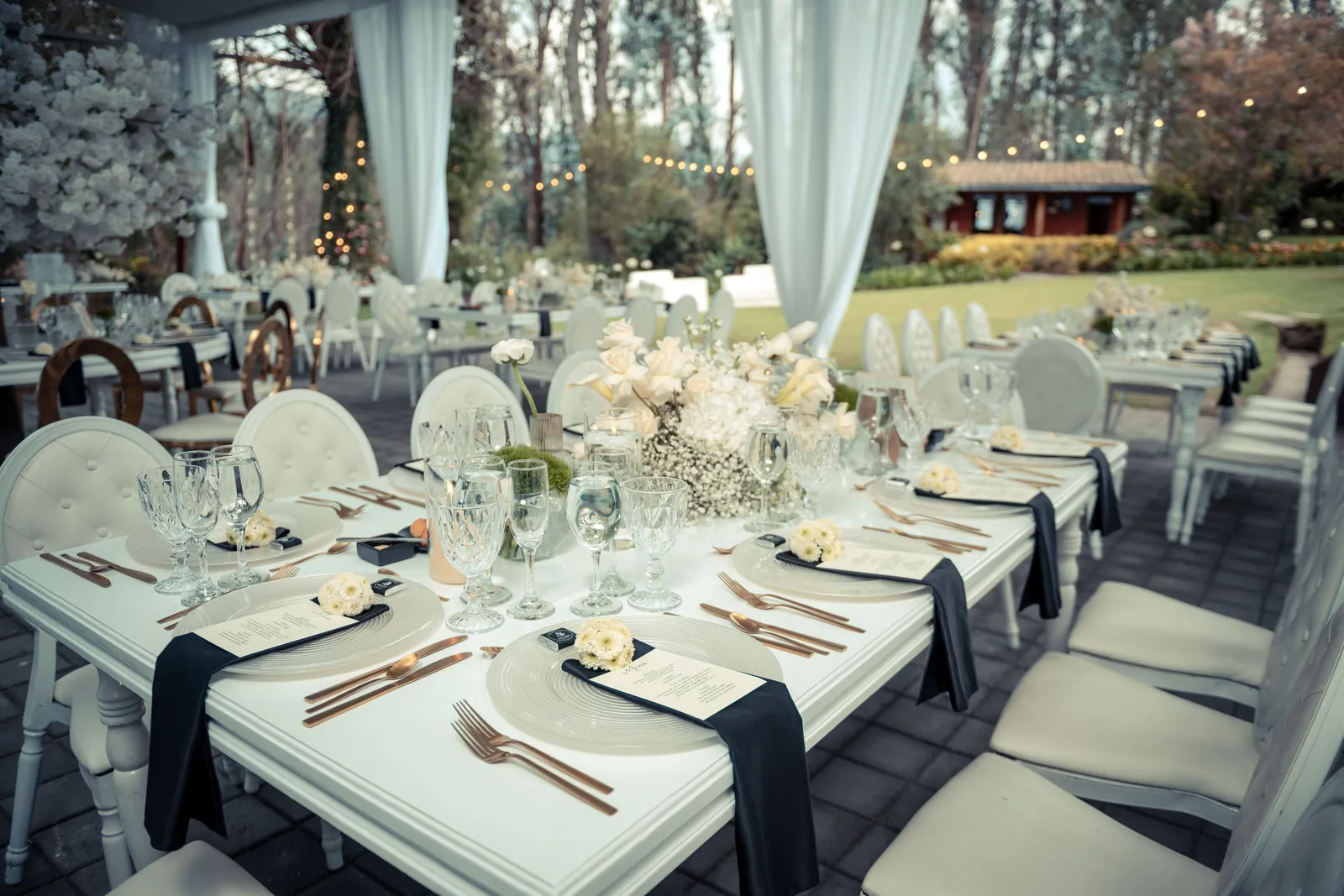Mesas montadas en la boda de Andre y Byron en Villa Fiorenza, con cristalería y cubertería en tono cobre
