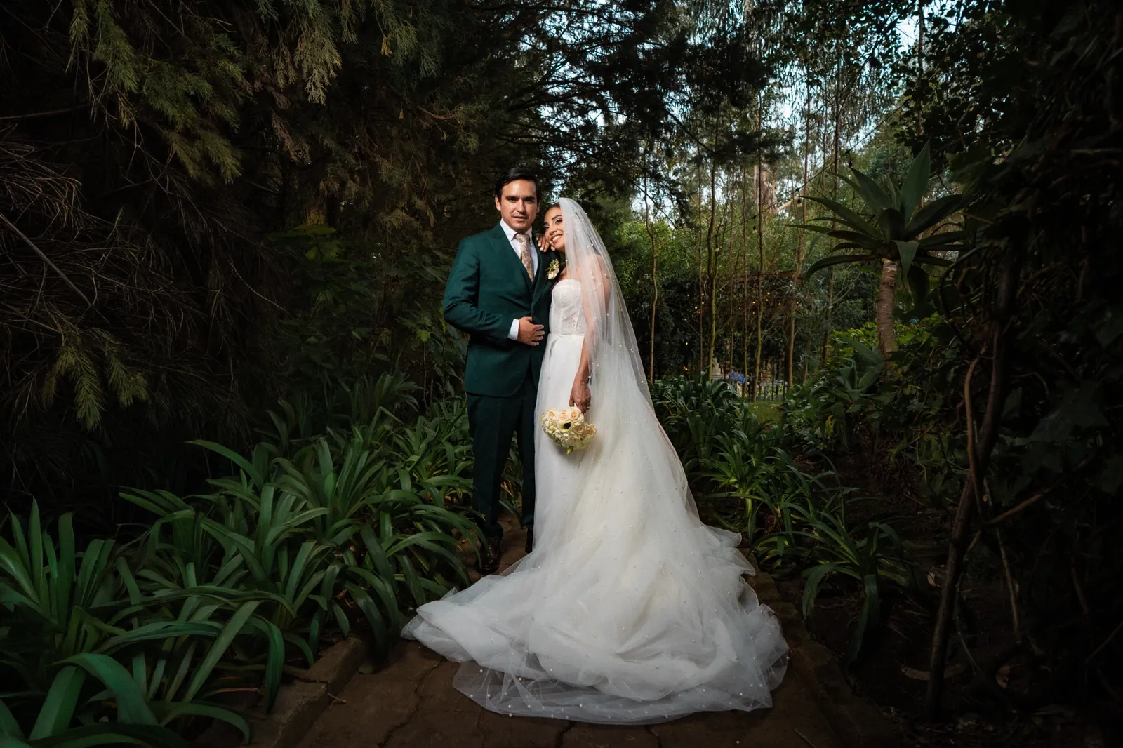 Daya y Marco entre la vegetación de Villa Fiorenza, quinta para bodas en Puembo, valle de Quito