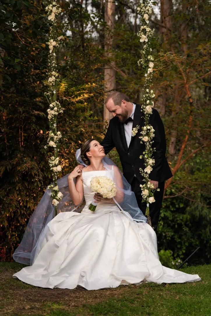 Novios en un columpio de flores en el bosque, en una boda real en Puembo, Quito