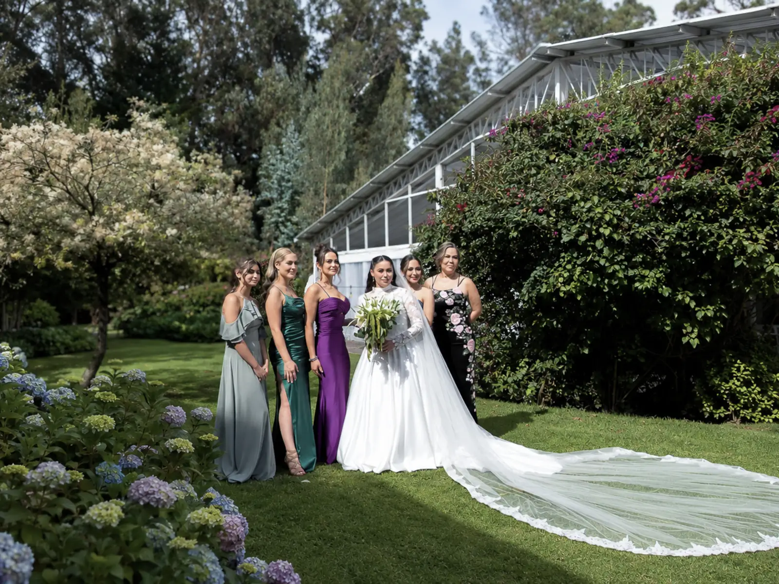 Novia y damas de honor en los jardines de Villa Fiorenza, quinta para bodas en Puembo, Quito