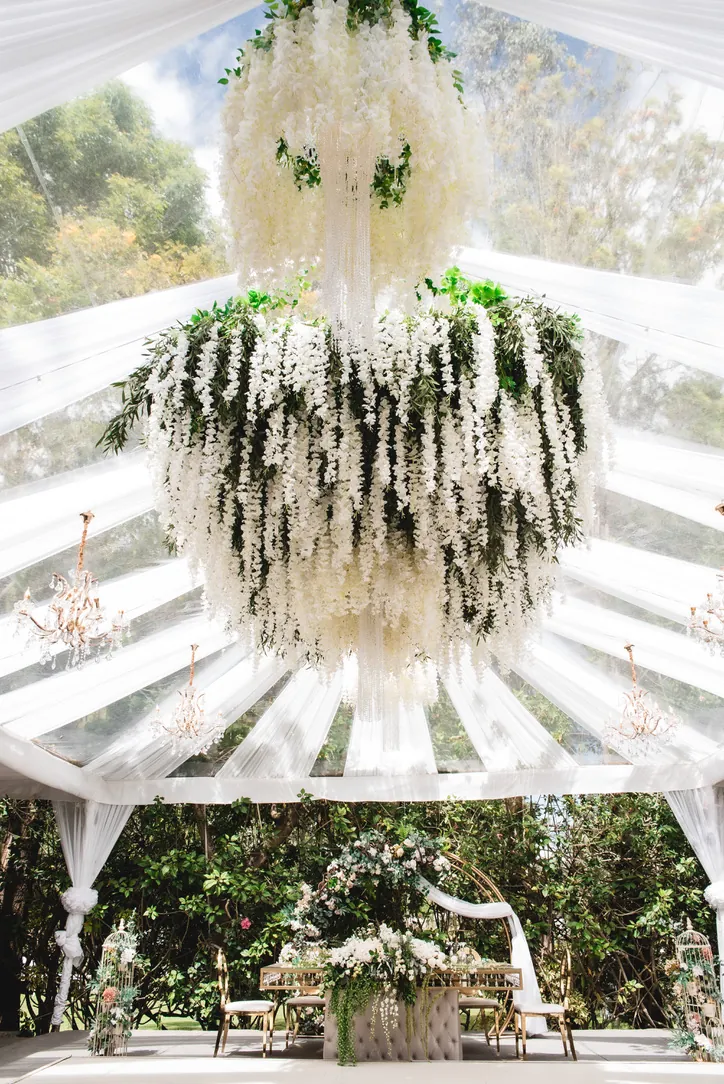 Carpa de techo transparente con candelabro floral colgante en una boda en Villa Lagos, Puembo