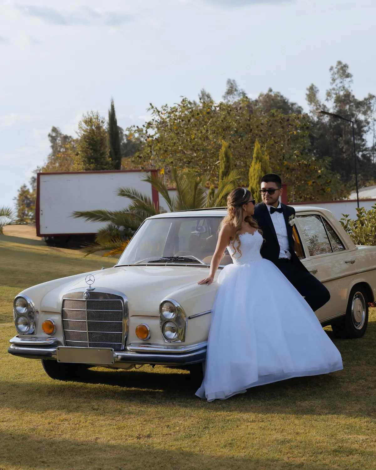 Sol y Gus junto a un Mercedes clásico en los jardines de Villa Lagos