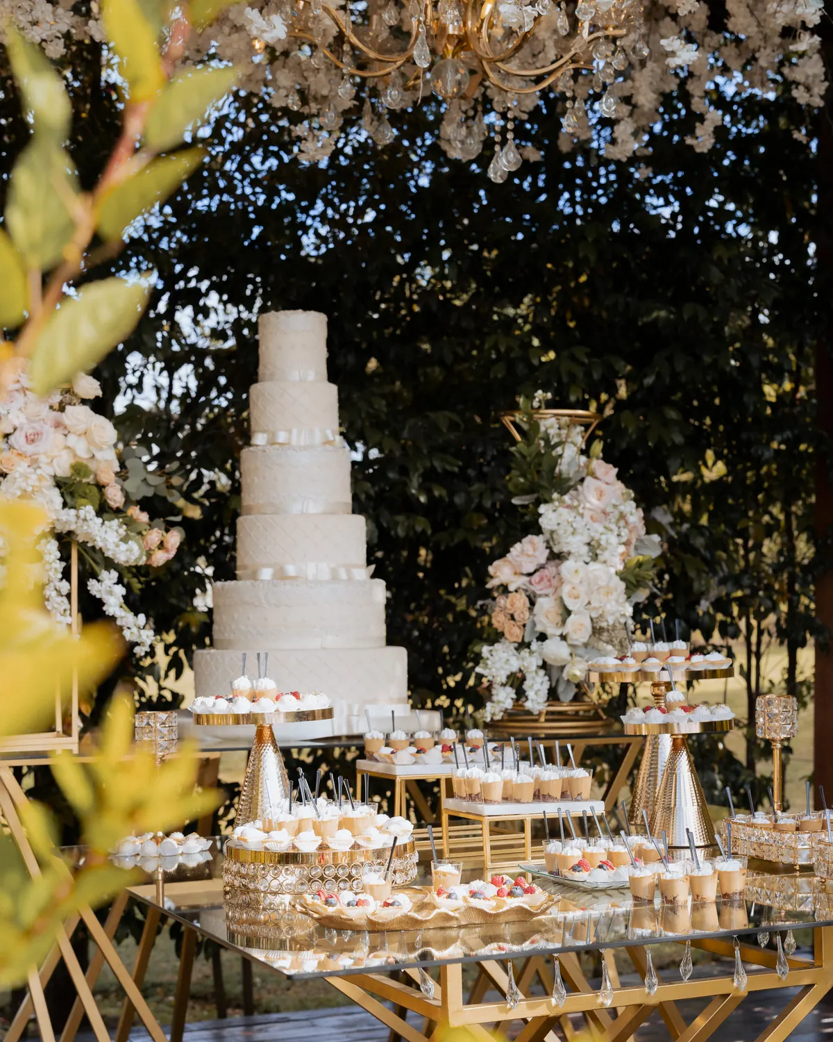 Torta de varios pisos y mesa de postres montada en dorado en la boda de Sol y Gus